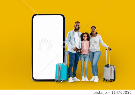 Happy family with luggage beside a large smartphone display conveying the idea of digital travel application technology, isolated on a yellow backdrop Happy family with luggage beside a large smartphone display conveying the idea of digital travel application technology, isolated on a yellow backdrop 114703056