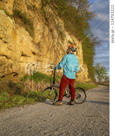 senior male cyclist with a folding bike on Steamboat Trace, bike trail converted from an abandoned railroad, near Peru, Nebraska, springtime morning scenery senior male cyclist with a folding bike on Steamboat Trace, bike trail converted from an abandoned railroad, near Peru, Nebraska, springtime morning scenery 114703222