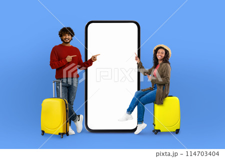 Diverse couple in casual attire gesturing towards a giant mobile screen ideal for technology, applications, online offers, digital representation, and isolated concepts 114703404