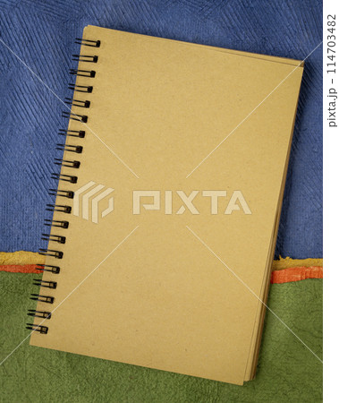 blank spiral notebook against abstract paper landscape, vertical poster blank spiral notebook against abstract paper landscape, vertical poster 114703482