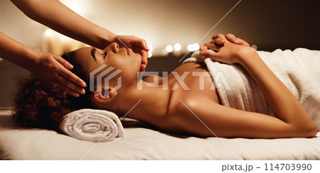Face massage. African-american woman getting spa treatment, side view Face massage. African-american woman getting spa treatment, side view 114703990