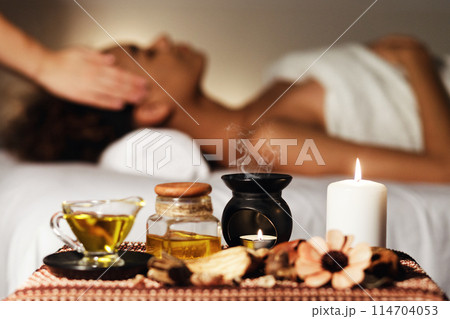 African woman having face massage, relaxing in spa salon and enjoying aroma therapy African woman having face massage, relaxing in spa salon and enjoying aroma therapy 114704053