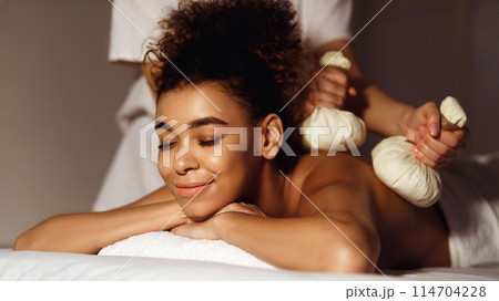 Body care. Spa body massage with hot herbal balls for deep relaxation Body care. Spa body massage with hot herbal balls for deep relaxation 114704228
