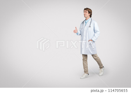 Cheerful male doctor strides forward, wearing white lab coat and stethoscope, gesturing conversationally with his hand out, evoking sense of approachability and friendliness Cheerful male doctor strides forward, wearing white lab coat and stethoscope, gesturing conversationally with his hand out, evoking sense of approachability and friendliness 114705655