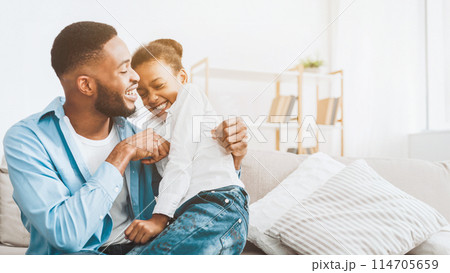Father and daughter playing together, tickling and having fun at home, empty space 114705659