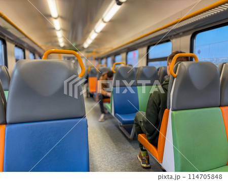 Empty train interior with passengers seated and reading Empty train interior with passengers seated and reading 114705848