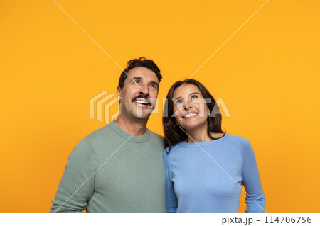 Happy funny senior caucasian family in casual look up at empty space, isolated on orange studio background. Surprise, relationships and idea, attention sale, ad and offer Happy funny senior caucasian family in casual look up at empty space, isolated on orange studio background. Surprise, relationships and idea, attention sale, ad and offer 114706756