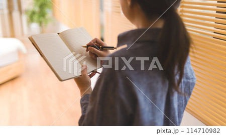 メモ帳を持つ女性 114710982