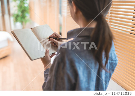 手帳を持つ女性 114711039
