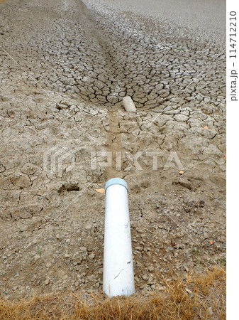 Dried soil surface, waterless sewer pipes after long time hot season at Mekong Delta, Viet Nam, climate change and el nino make hard weather of global, drought field affect to food Security 114712210