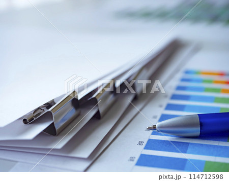 テーブルに置かれたグラフと書類 114712598