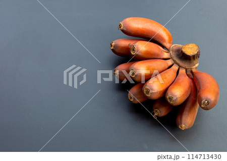 Red banana on dark background. 114713430