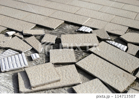 Cracked brown tiles on cement floor 114713507