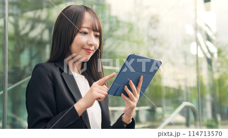 街角でタブレットPCを使う女性ビジネスウーマン 114713570