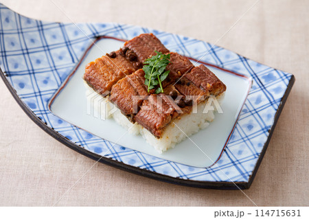 舟形のうつわに盛られた鰻の押し寿司 114715631