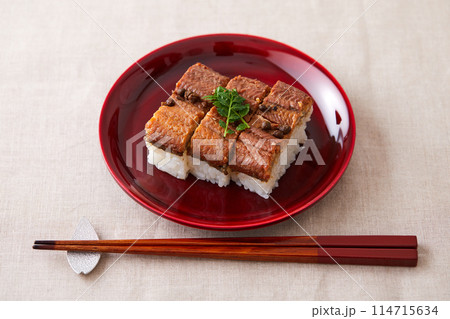 朱塗りのお皿に盛られた鰻の押し寿司 114715634
