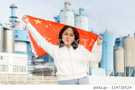 Happy young woman with flag of China against background of factory 114716524