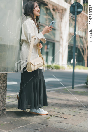 待ち合わせ場所に一番乗りをした若い女性の全身姿 114716538