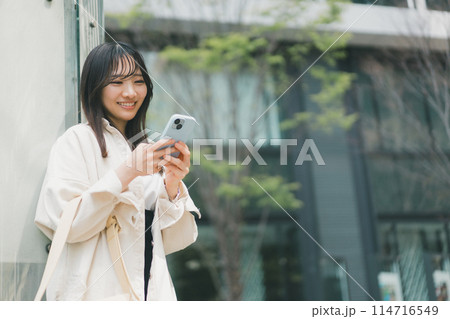 両手フリック入力をする若い女性 両手フリック入力をする若い女性 114716549