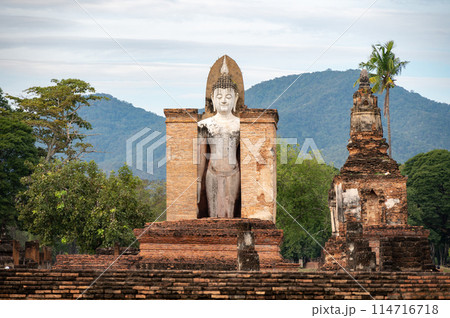 An old standing Buddha statue in Wat Mahathat temple the most important and impressive temple compound in Sukhothai Historical Park. 114716718