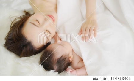 生後一ヶ月の息子と添い寝する母親 生後一ヶ月の息子と添い寝する母親 114718401