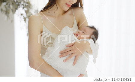 生後1ヶ月の赤ちゃんを抱っこする母親 生後1ヶ月の赤ちゃんを抱っこする母親 114718451