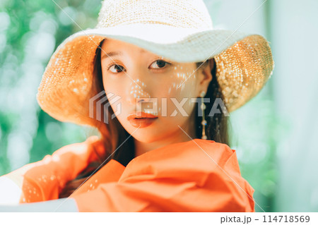 麦わら帽子をかぶる若い女性 114718569