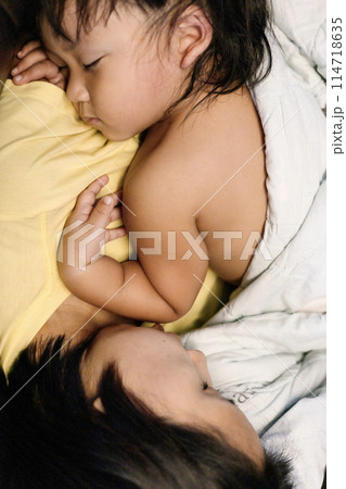 Sleeping mother and the child lying at home on the floor. 114718635