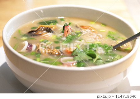Boiled rice soup with squid, mussels and shrimp in white bowl. Asian breakfast style. Seafood Porridge. Boiled rice soup with squid, mussels and shrimp in white bowl. Asian breakfast style. Seafood Porridge. 114718640