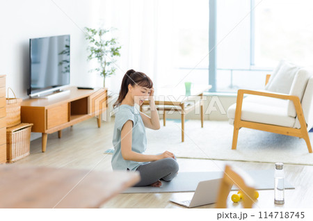 パソコンを見ながらストレッチをする女性 ヨガ 114718745