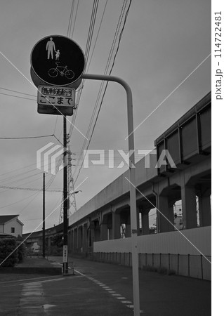 （モノクロ写真）高架線脇の道路立つ道路標識：歩行者、自転車 114722481