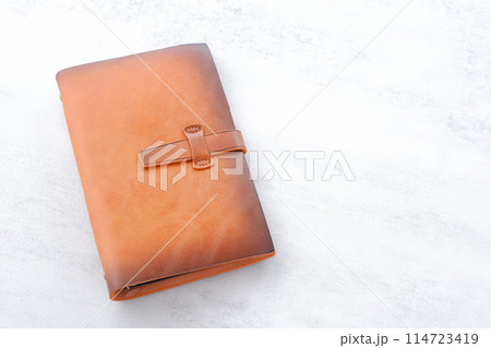 茶色の革のシステム手帳でデスクワークをしているイメージ 茶色の革のシステム手帳でデスクワークをしているイメージ 114723419
