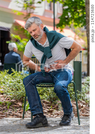 Mature man feeling sudden strong abdominal stomach ache gastritis problem poisoning diarrhea outdoor Mature man feeling sudden strong abdominal stomach ache gastritis problem poisoning diarrhea outdoor 114723680