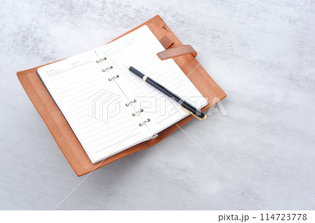 リング式のシステム手帳を開いてデスクワークをしているイメージ リング式のシステム手帳を開いてデスクワークをしているイメージ 114723778