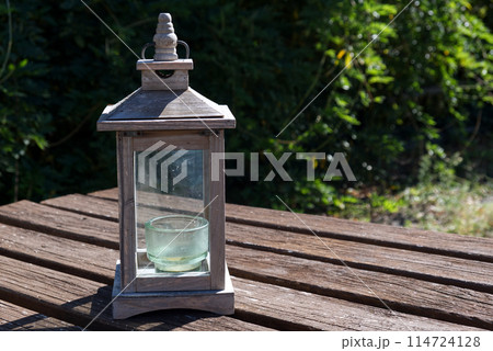 garden candlestick on a wooden table garden candlestick on a wooden table 114724128