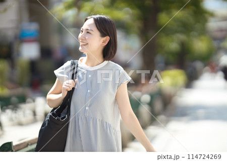 旅行で街中を歩く若い女性 旅行で街中を歩く若い女性 114724269