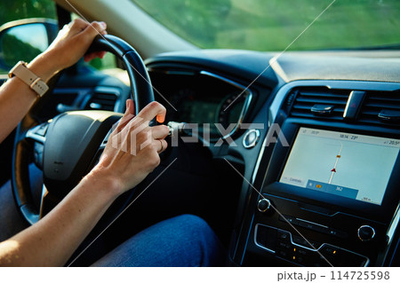 Inside view of woman driving car on countryside road Inside view of woman driving car on countryside road 114725598