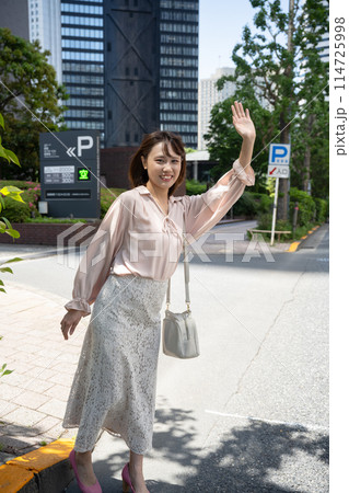 タクシーに手を挙げる女性 114725998
