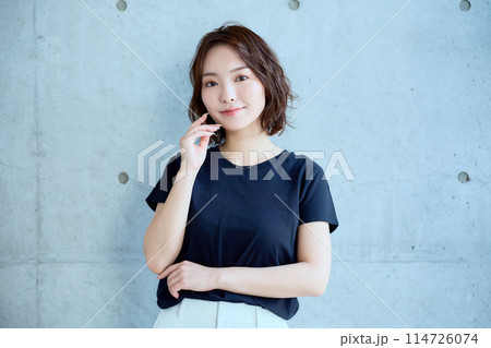 コンクリート背景に立つ女性のポートレート コンクリート背景に立つ女性のポートレート 114726074