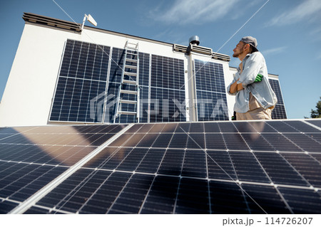 Man on a rooftop with solar panels Man on a rooftop with solar panels 114726207
