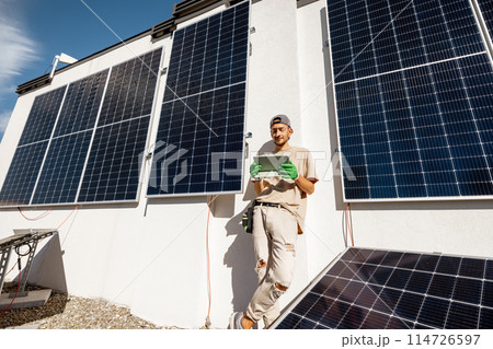 Technician with a digital tablet on a rooftop with solar power station 114726597