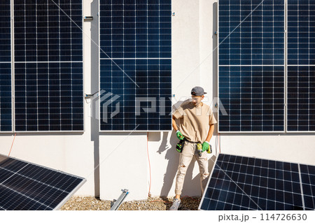 Man on a rooftop with solar panels 114726630
