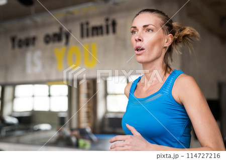 Beautiful sport woman in gym, running on treadmill. Routine workout for woman's physical and mental health. Beautiful sport woman in gym, running on treadmill. Routine workout for woman's physical and mental health. 114727216