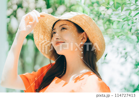 麦わら帽子をかぶる若い女性 114727413