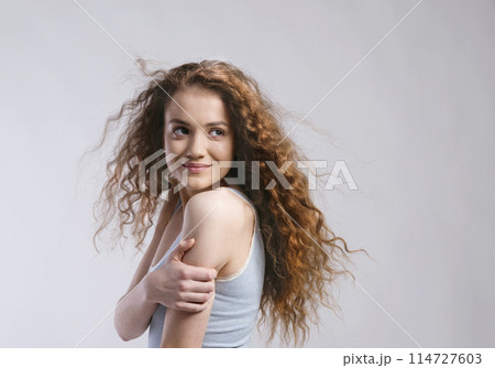 Portrait of a gorgeous teenage girl with curly hair. Studio shot, white background with copy space Portrait of a gorgeous teenage girl with curly hair. Studio shot, white background with copy space 114727603