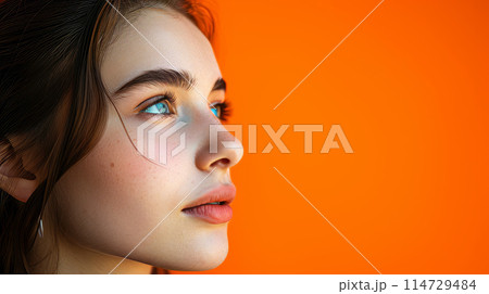 Portrait of a young beautiful girl on an orange background. Portrait of a young beautiful girl on an orange background. 114729484