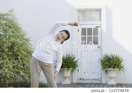 庭で体操をするシニア女性 114729839