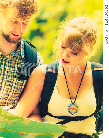 Hikers backpackers couple reading map on trip. 114730662