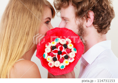 Couple kissing behind candy bunch flowers. Love. Couple kissing behind candy bunch flowers. Love. 114731153