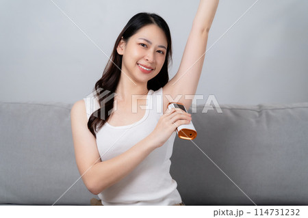 A beautiful woman is epilating her armpits using an IPL laser hair removal epilator device. A beautiful woman is epilating her armpits using an IPL laser hair removal epilator device. 114731232